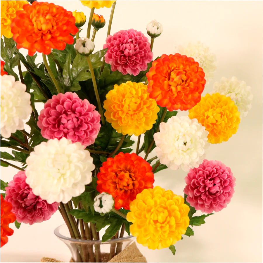 Artificial ruffled chrysanthemum flower stem in white, yellow and hot pink displayed in a glass vase
